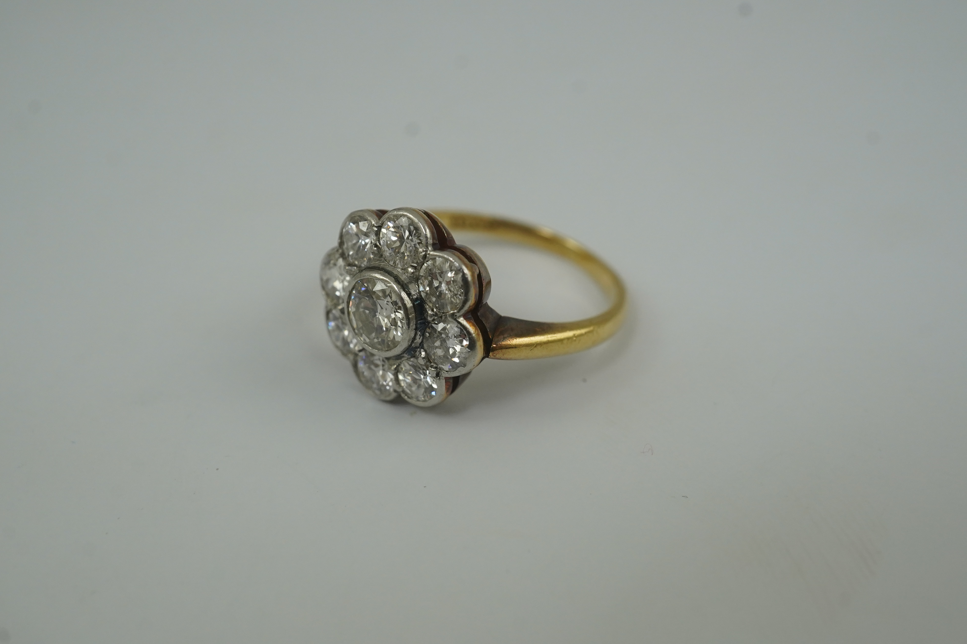 A mid 20th century 18ct gold and nine stone diamond set flower head cluster ring